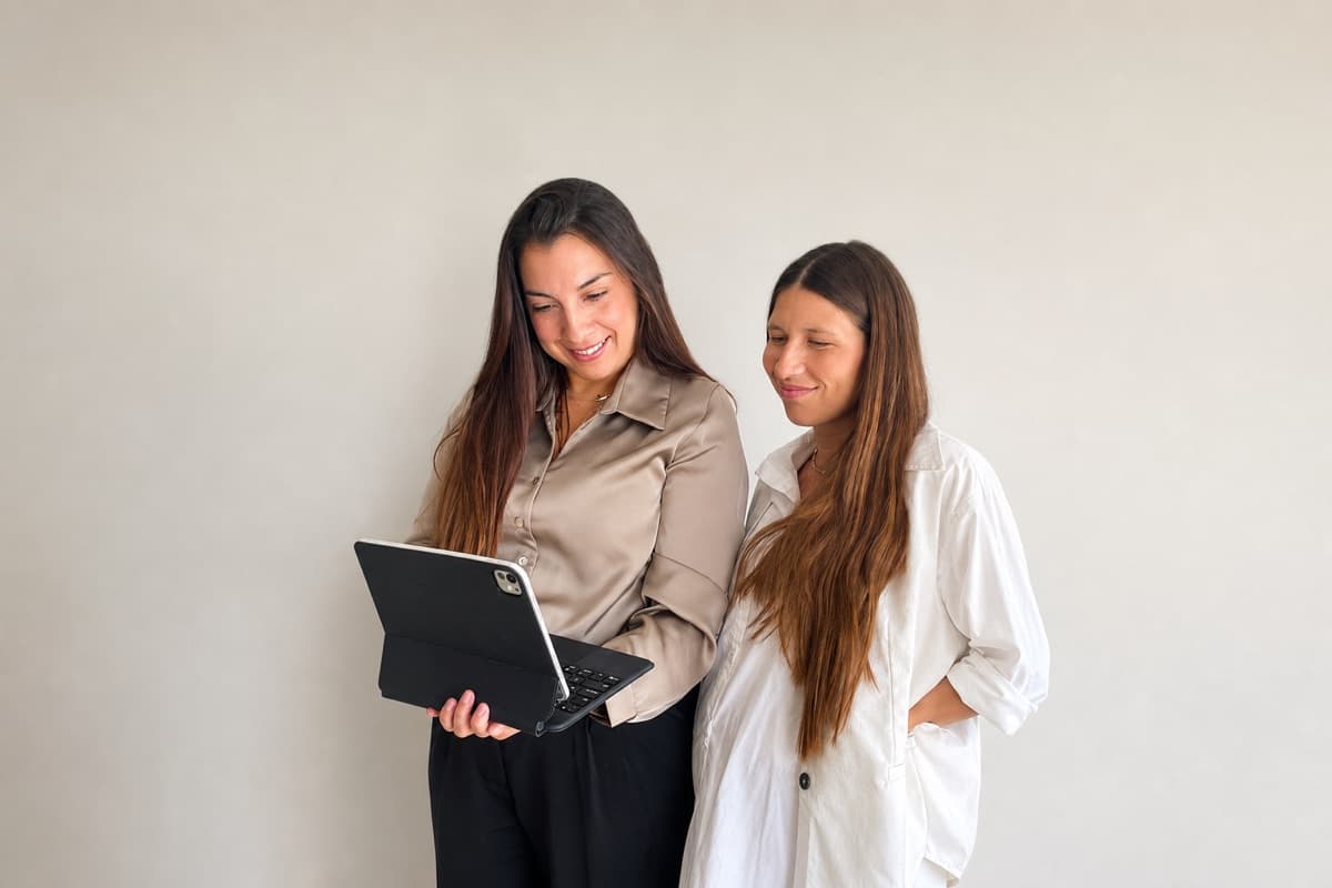 Julieta con una participante del Programa de Liderazgo Financiero, mirando una tablet